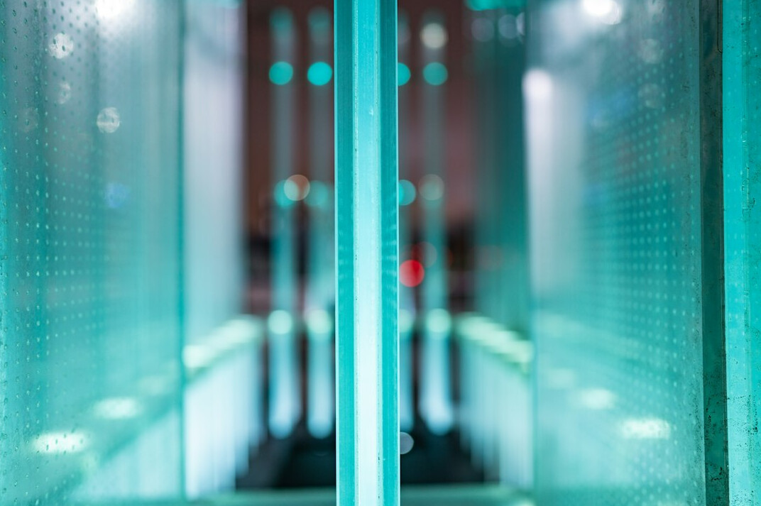 Server room with rows of data racks and blue lighting