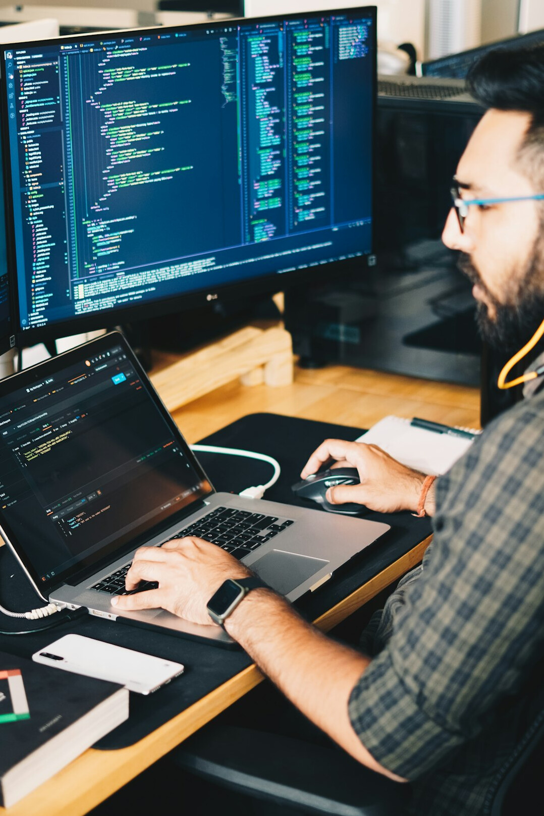 software developer at desk with multiple screens