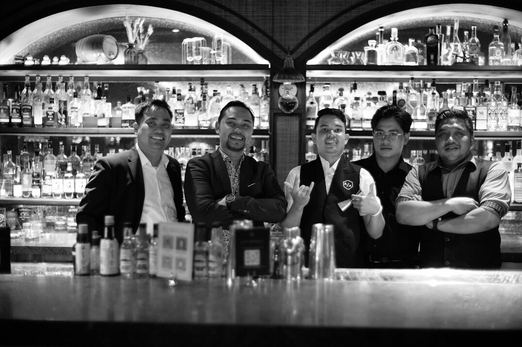 Group portrait of four diverse technology professionals smiling together